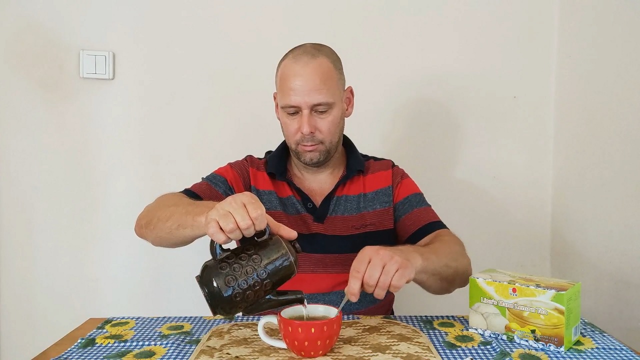 Pouring hot water on DXN Lion's Mane instant Lemon Tea powder